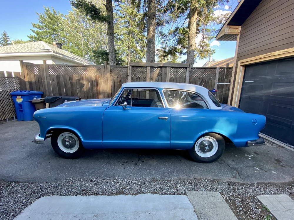 Volvo classique bleue au toit blanc vue de profil
